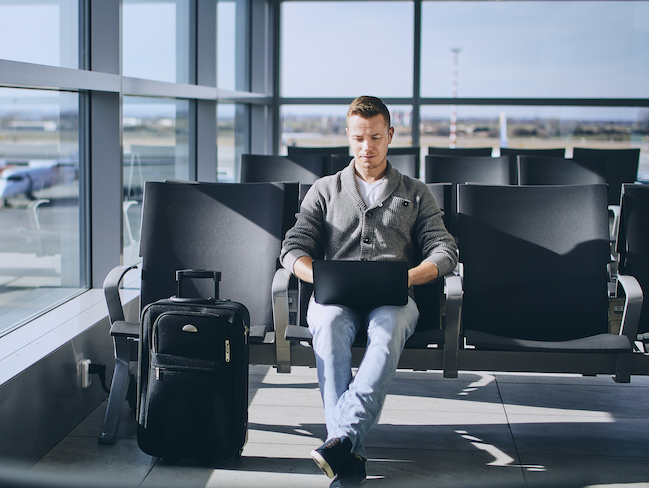 Man sitting in airport on laptop